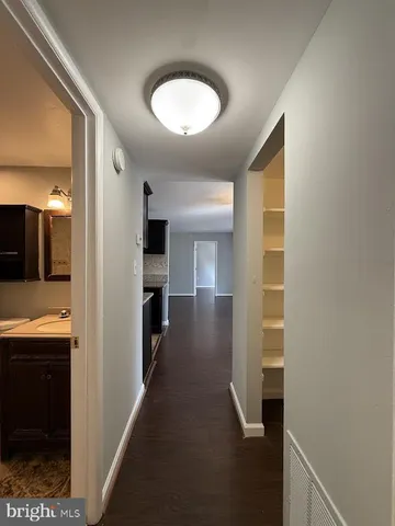 a view of a hallway with wooden shelves