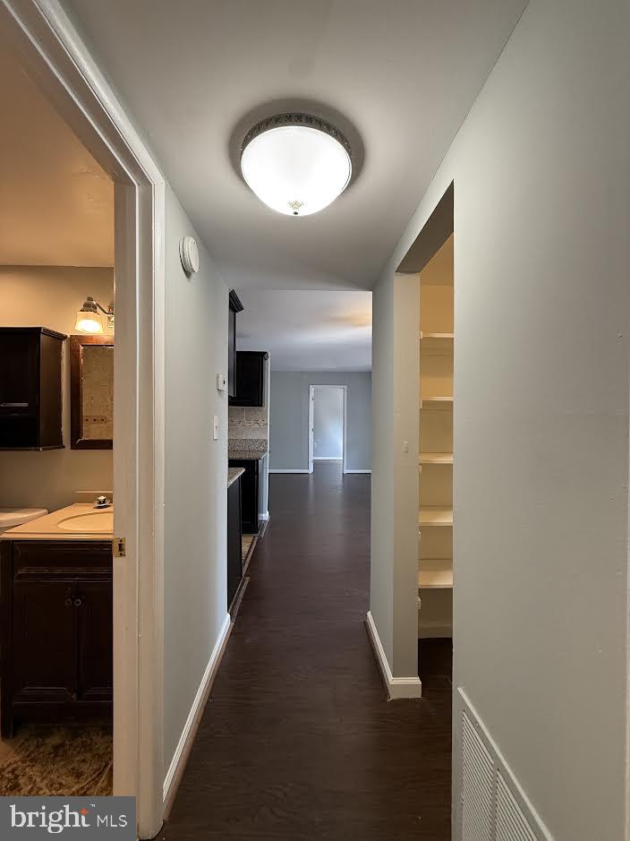 3419 University Boulevard West, Unit 203 Kensington, MD 20895 - Photo 14 of 25 a view of a hallway with wooden shelves