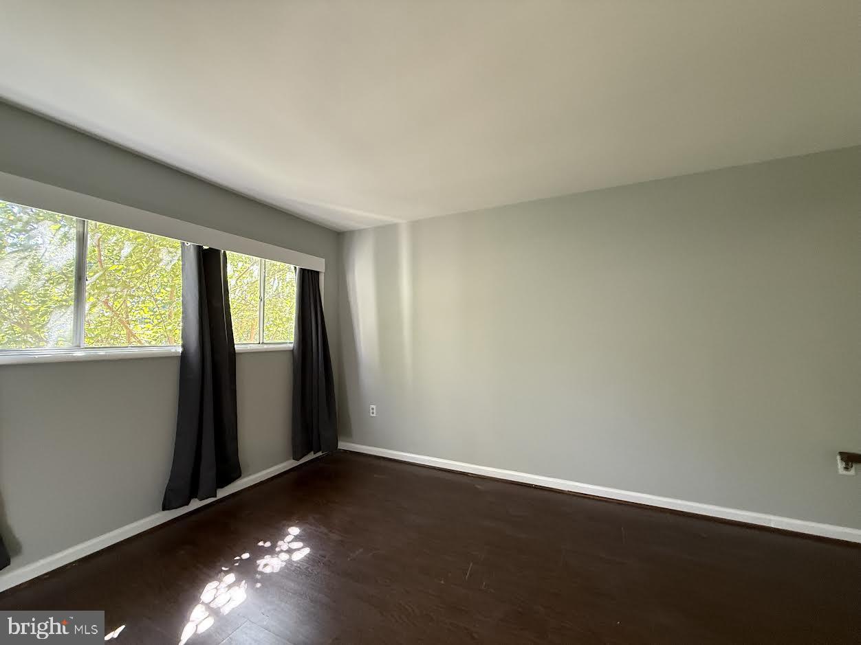 3419 University Boulevard West, Unit 203 Kensington, MD 20895 - Photo 16 of 25 an empty room with wooden floor and windows
