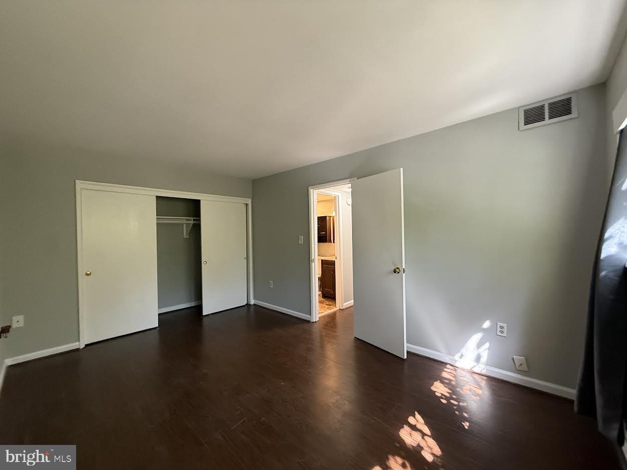 3419 University Boulevard West, Unit 203 Kensington, MD 20895 - Photo 17 of 25 a view of an empty room with wooden floor and a window