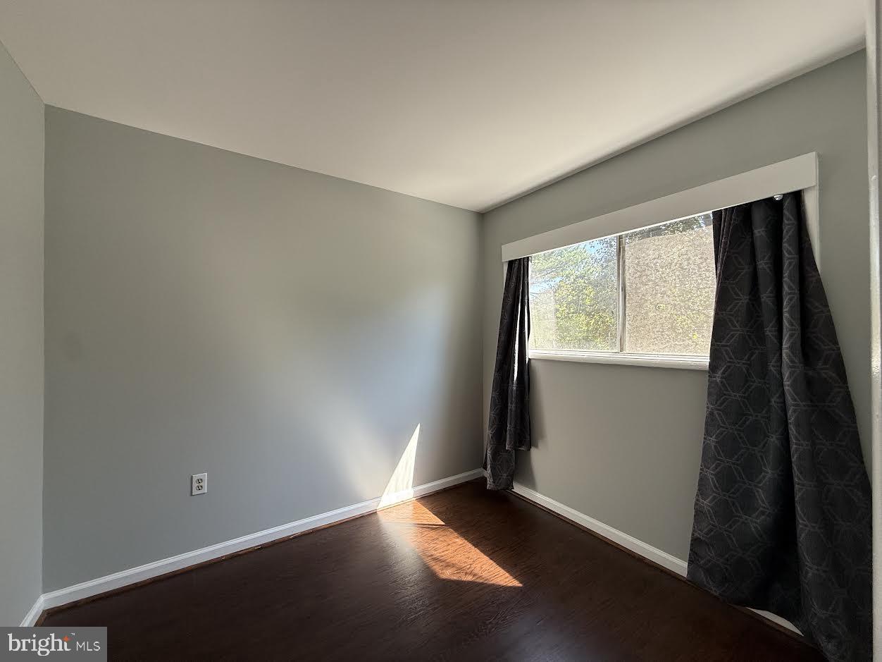 3419 University Boulevard West, Unit 203 Kensington, MD 20895 - Photo 18 of 25 an empty room with wooden floor and windows