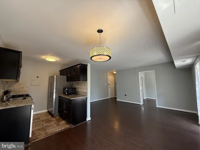a view of a kitchen with a sink wooden floor and a refrigerator