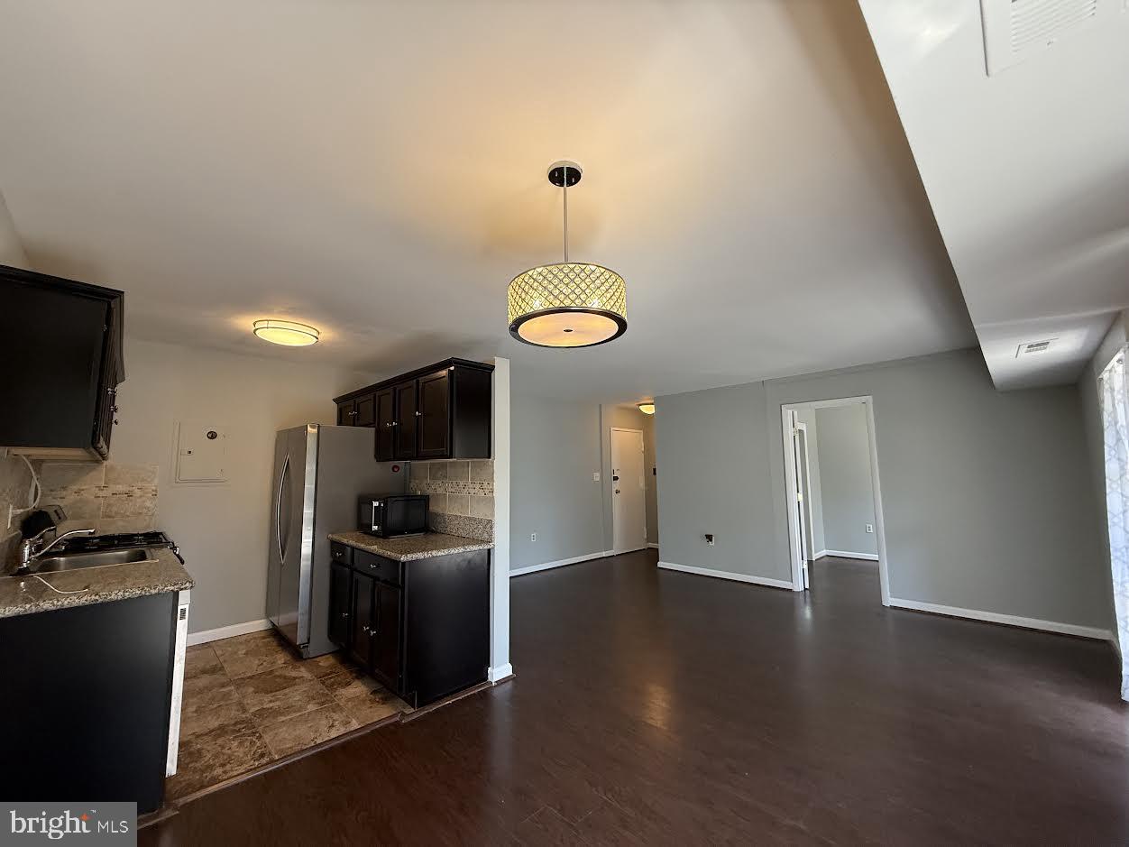 3419 University Boulevard West, Unit 203 Kensington, MD 20895 - Photo 6 of 25 a view of a kitchen with a sink wooden floor and a refrigerator