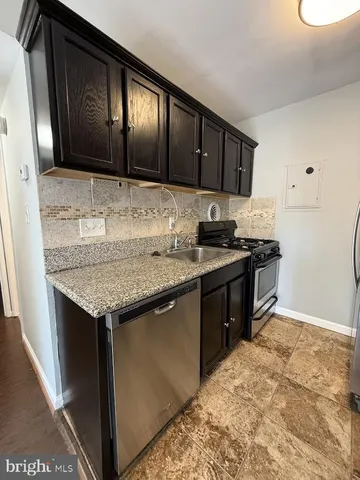 a kitchen with granite countertop stainless steel appliances and wooden cabinets