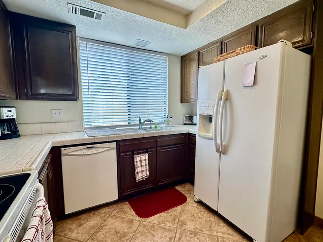 a kitchen with stainless steel appliances granite countertop a refrigerator and a sink