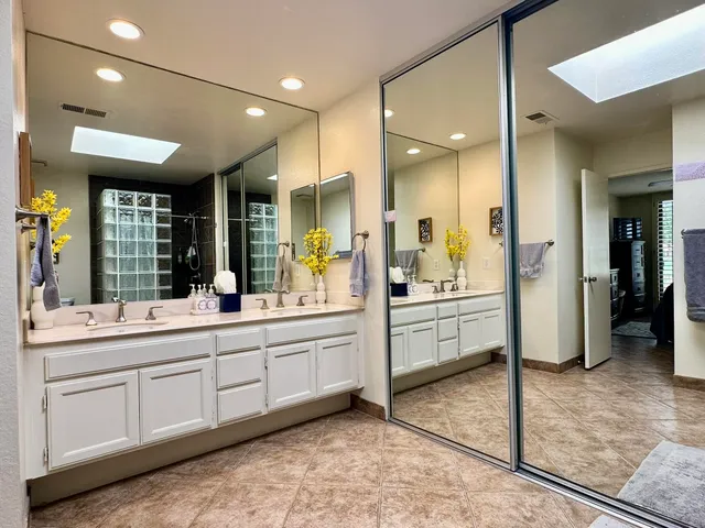 a large bathroom with a large mirror vanity and shower