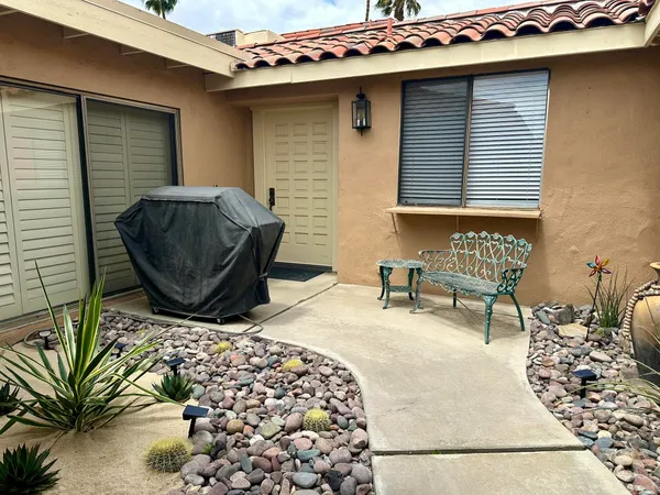 a backyard of a house with table and chairs