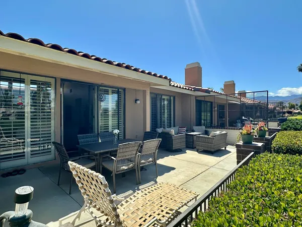a view of a patio with couches table and chairs and potted plants