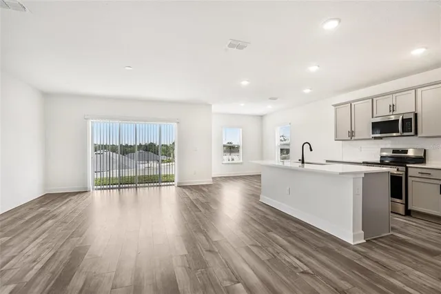a kitchen with stainless steel appliances a refrigerator and a stove top oven