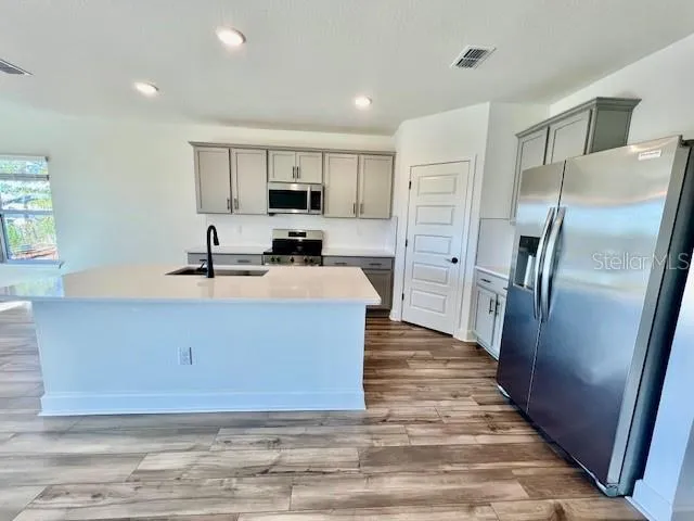 a kitchen with stainless steel appliances a refrigerator sink and cabinets
