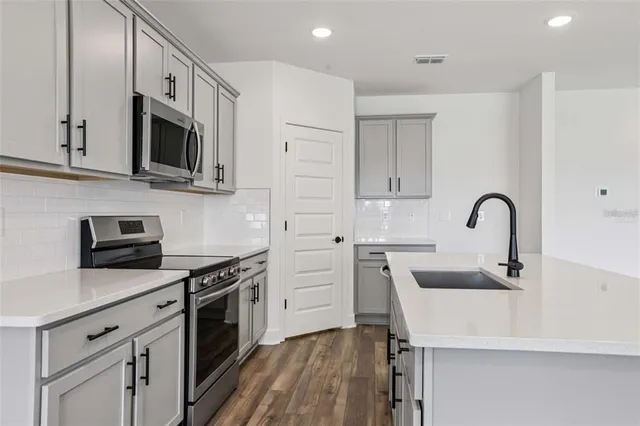 a kitchen with white cabinets stainless steel appliances and a sink