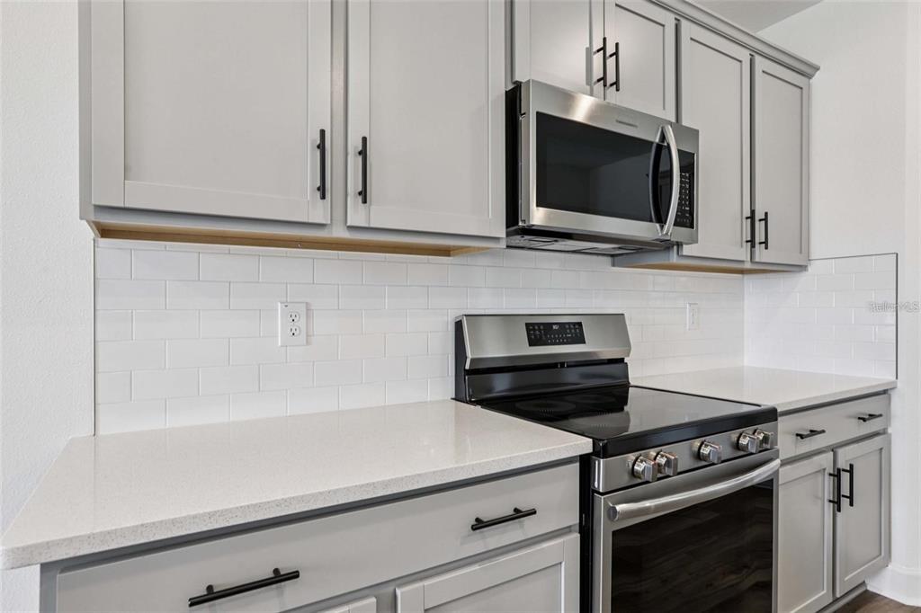 13112 Siam Drive Spring Hill, FL 34609 - Photo 21 of 46 a kitchen with microwave cabinets and stove top oven