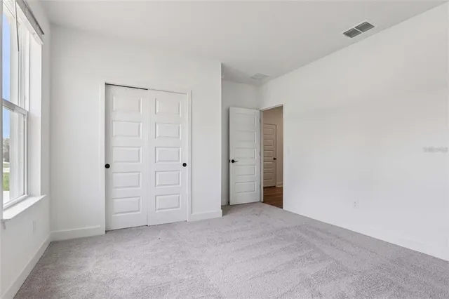 an empty room with windows and closet