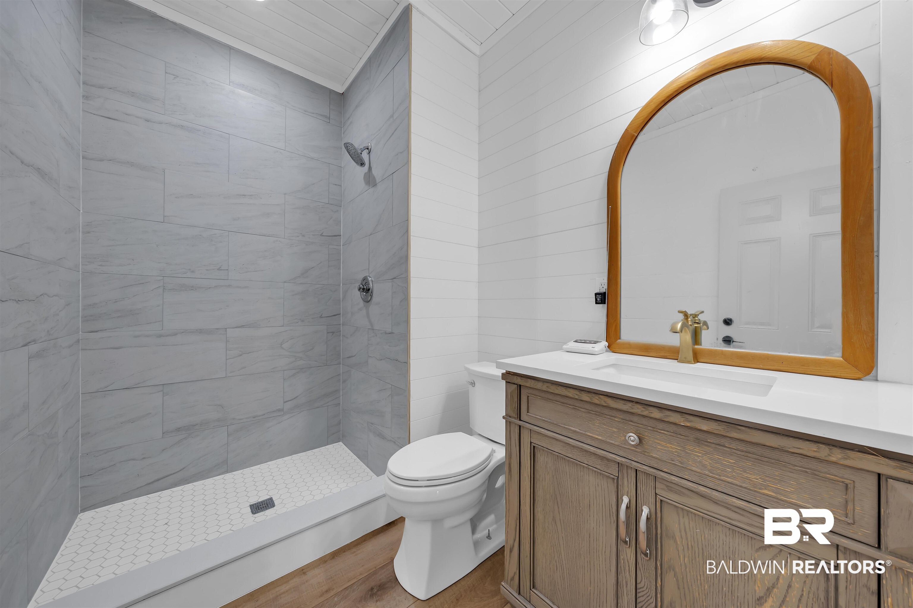 19058 James Road Gulf Shores, AL 36542 - Photo 37 of 49 Full bathroom featuring vanity, a stall shower, wood finished floors, and wooden walls