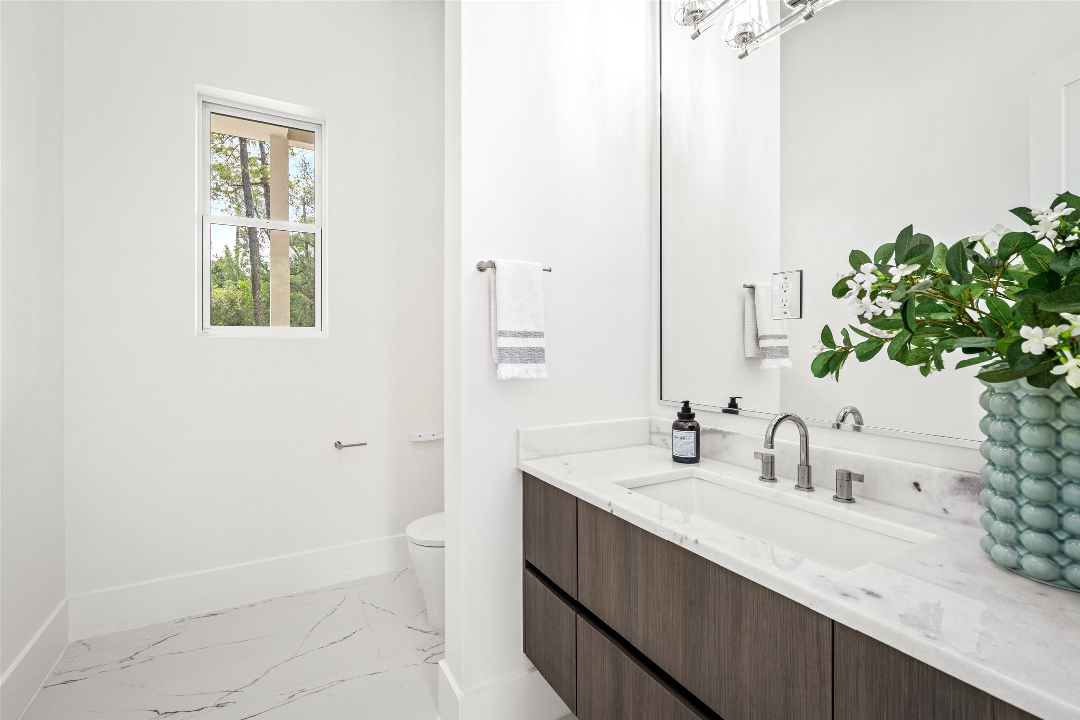625 Piney Point Road Houston, TX 77024 - Photo 18 of 42 a bathroom with a sink a toilet and a mirror