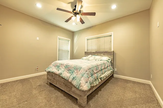 a bed sitting in a spacious bedroom next to a window