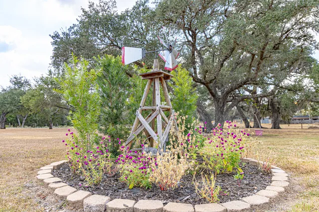 a front view of a house with a yard and fountain in middle