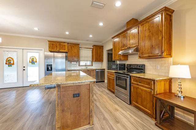 a kitchen with stainless steel appliances granite countertop a stove and a sink