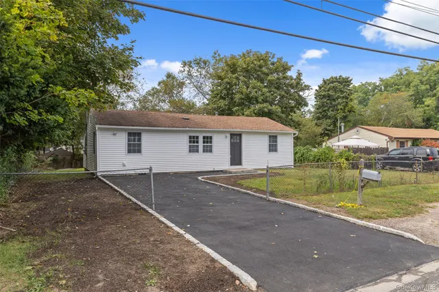 a view of a house with backyard and a tree