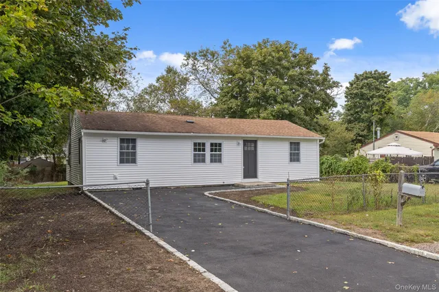a view of a house with a yard and large tree