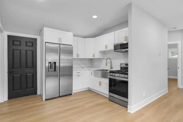 a kitchen with stainless steel appliances granite countertop a refrigerator and a stove top oven