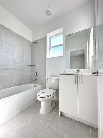 a bathroom with a toilet a sink a mirror and bathtub