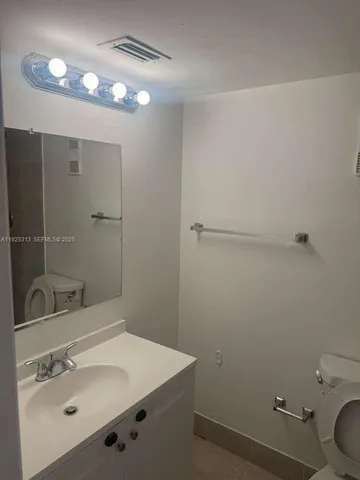 a bathroom with a sink toilet and vanity
