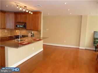 920 South Street, Unit 2 Philadelphia, PA 19147 - Photo 3 of 11 a kitchen with kitchen island a sink stainless steel appliances and cabinets