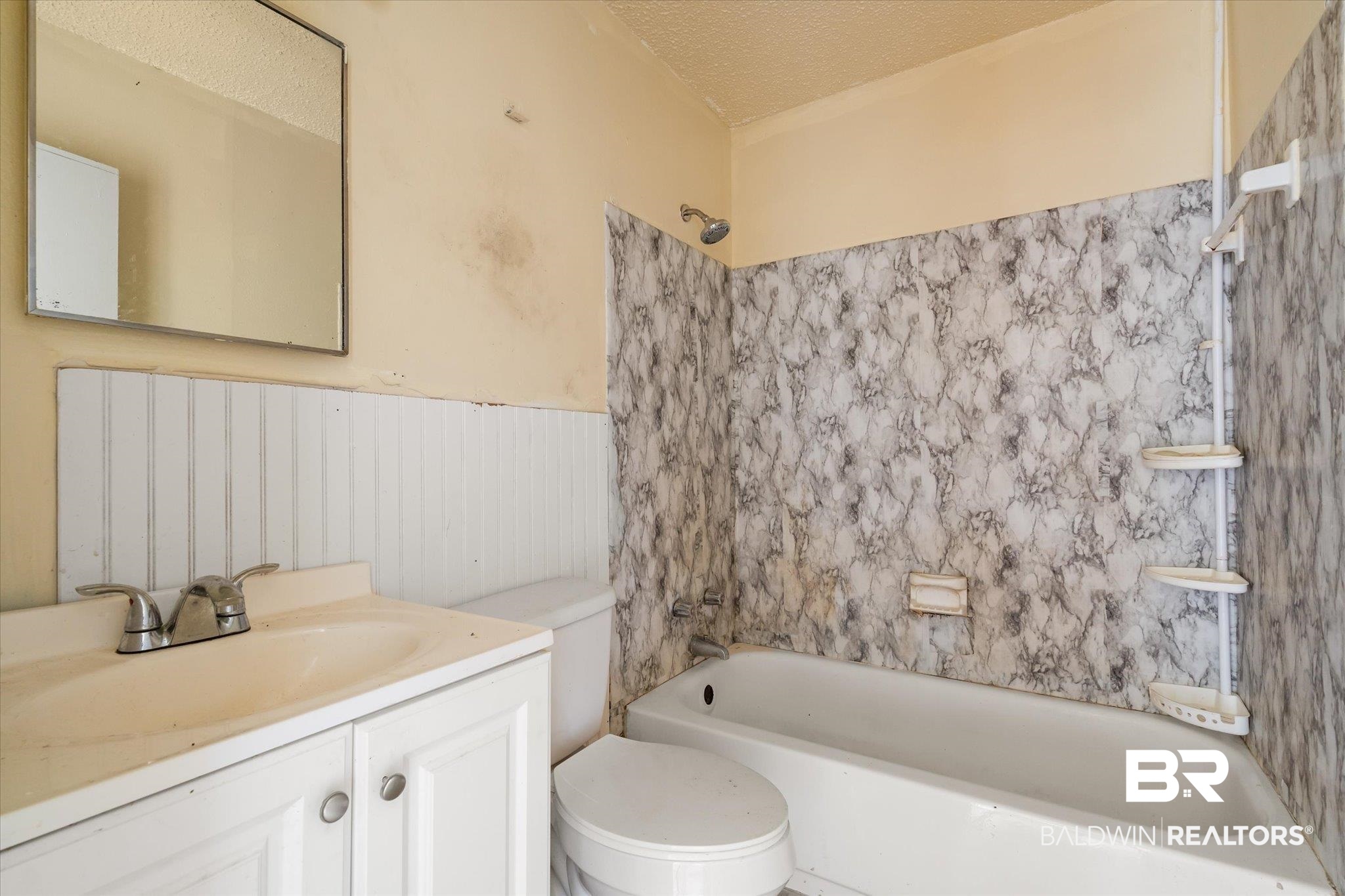 313 West 4th Avenue Foley, AL 36535 - Photo 13 of 20 Full bathroom featuring tiled shower / bath combo, vanity, a textured ceiling, and toilet
