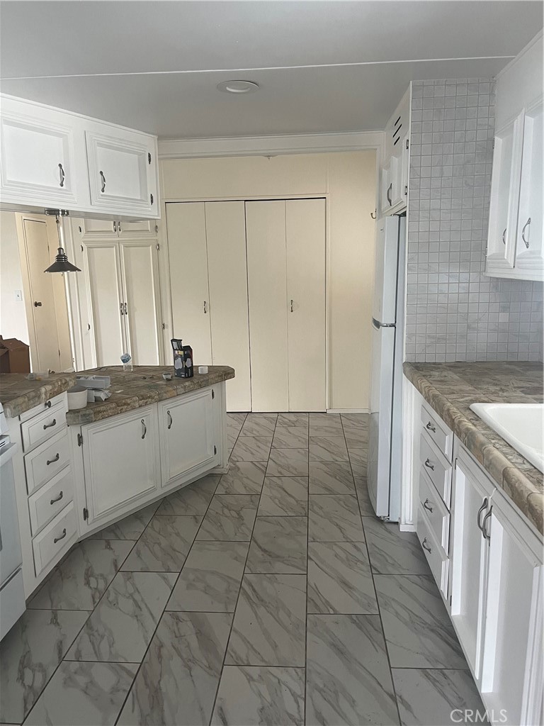 3950 Via Real, Unit 91 Carpinteria, CA 93013 - Photo 17 of 39 a large white kitchen with a stove a sink dishwasher and a refrigerator