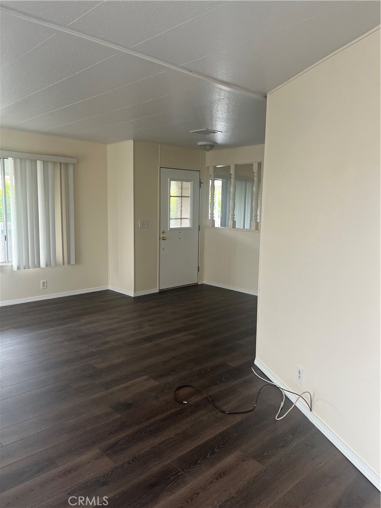 3950 Via Real, Unit 91 Carpinteria, CA 93013 - Photo 19 of 39 an empty room with wooden floor and windows