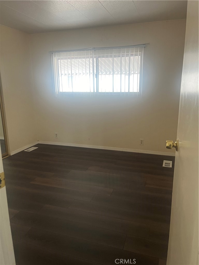 3950 Via Real, Unit 91 Carpinteria, CA 93013 - Photo 6 of 39 an empty room with wooden floor and windows