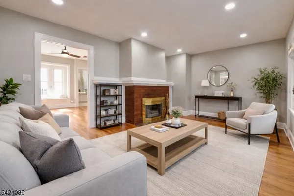 an empty room with wooden floor fireplace and windows