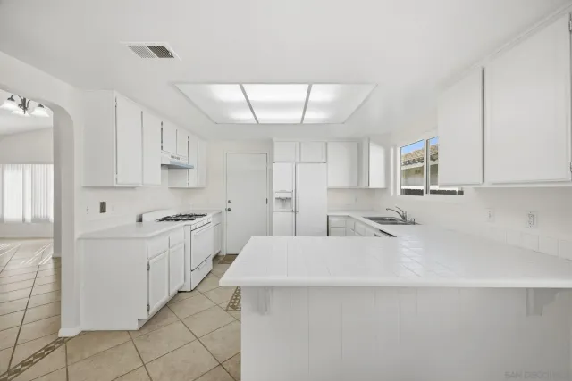 a large white kitchen with cabinets