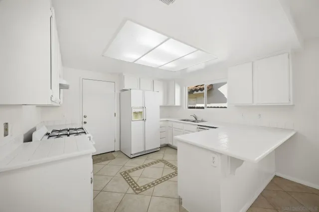 a kitchen with a refrigerator a stove a microwave and white cabinets