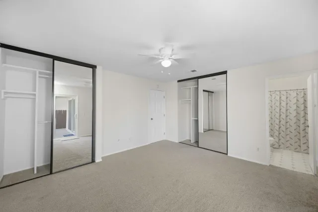 a view of an empty room and a ceiling fan window
