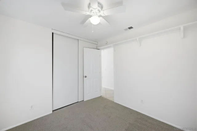 a view of a room with a ceiling fan and a shower