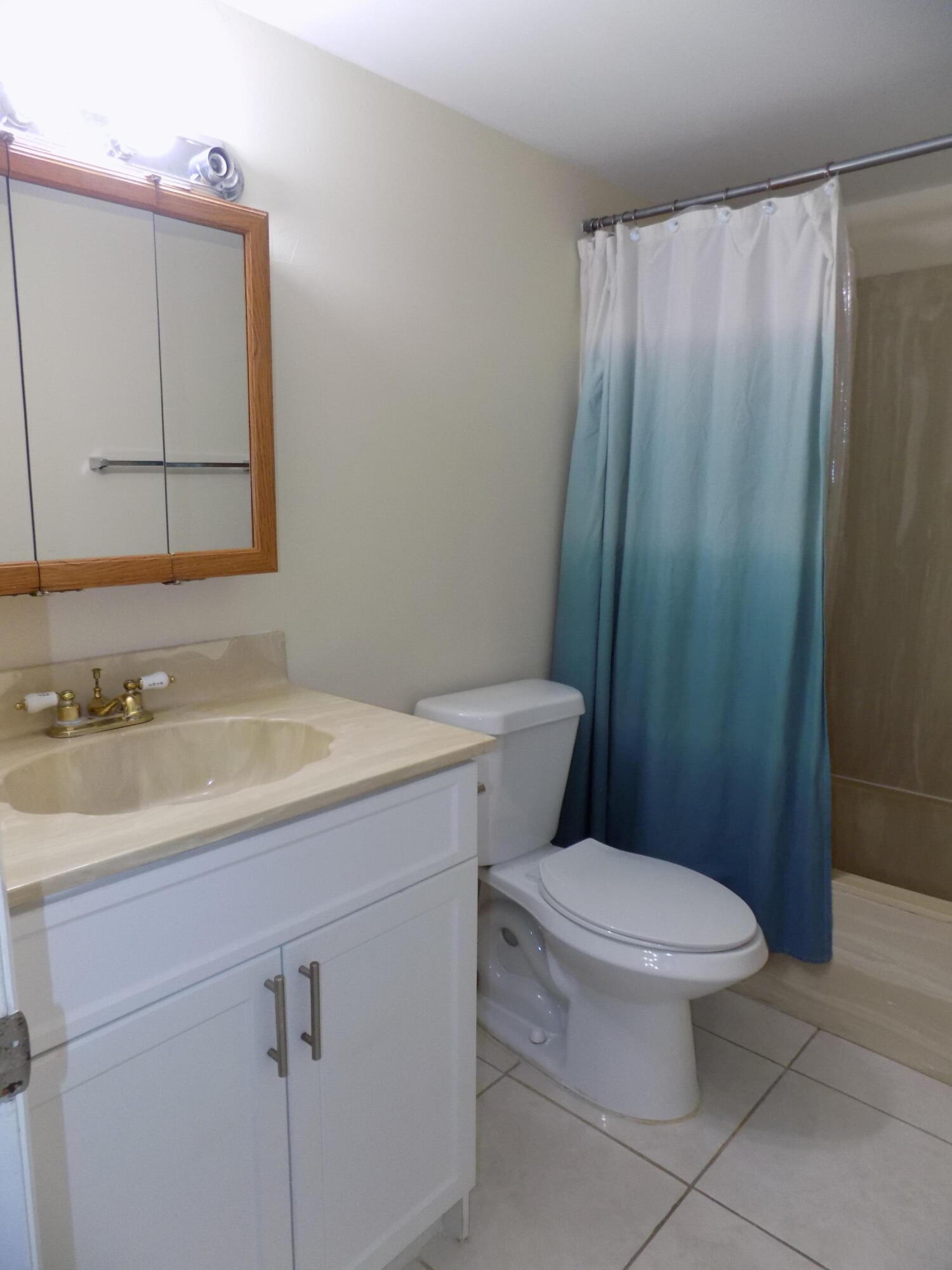 4181 South 57th Avenue, Unit B Greenacres, FL 33463 - Photo 13 of 25 a bathroom with a toilet a sink and mirror