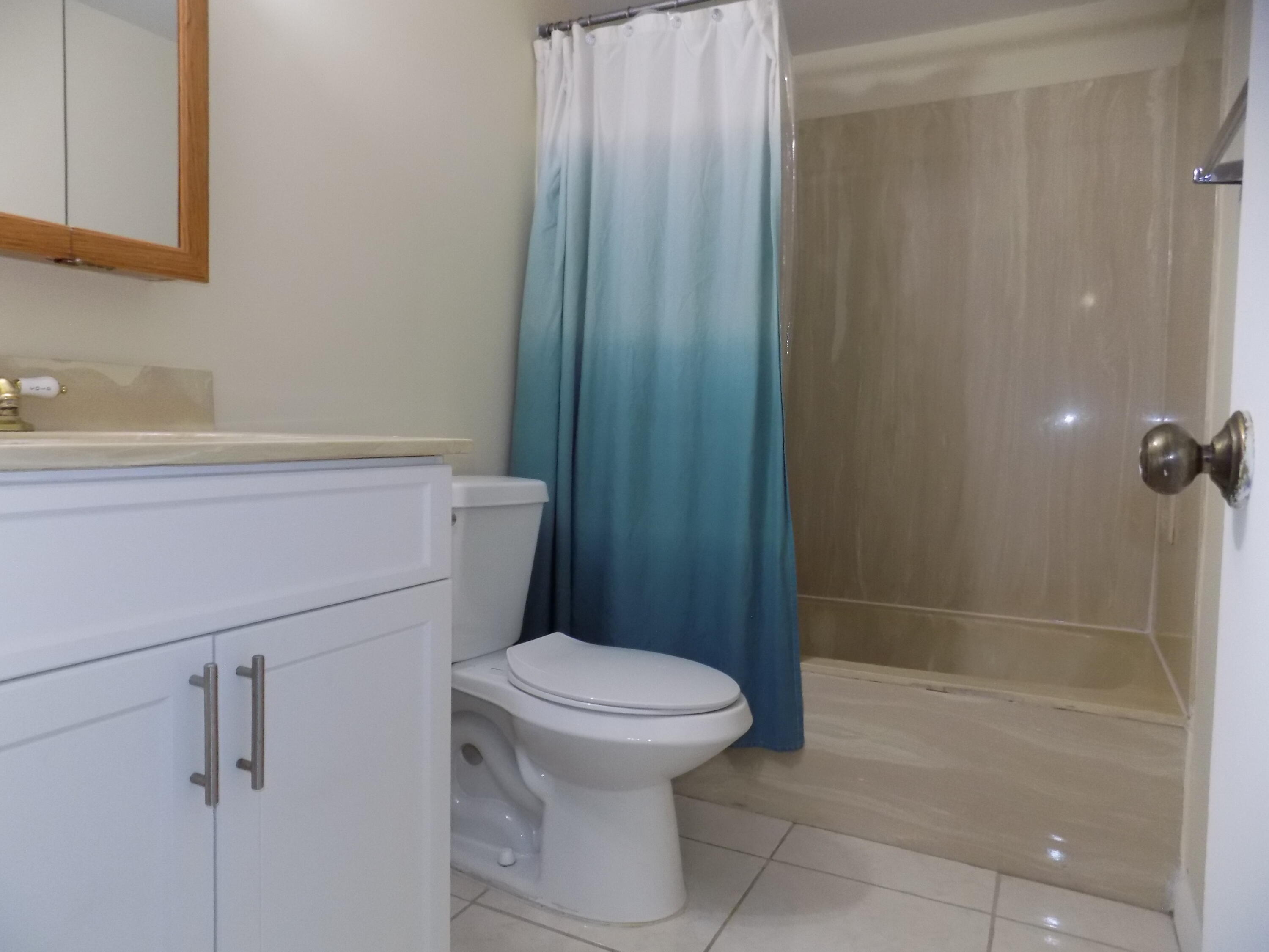 4181 South 57th Avenue, Unit B Greenacres, FL 33463 - Photo 14 of 25 a bathroom with a toilet and a shower