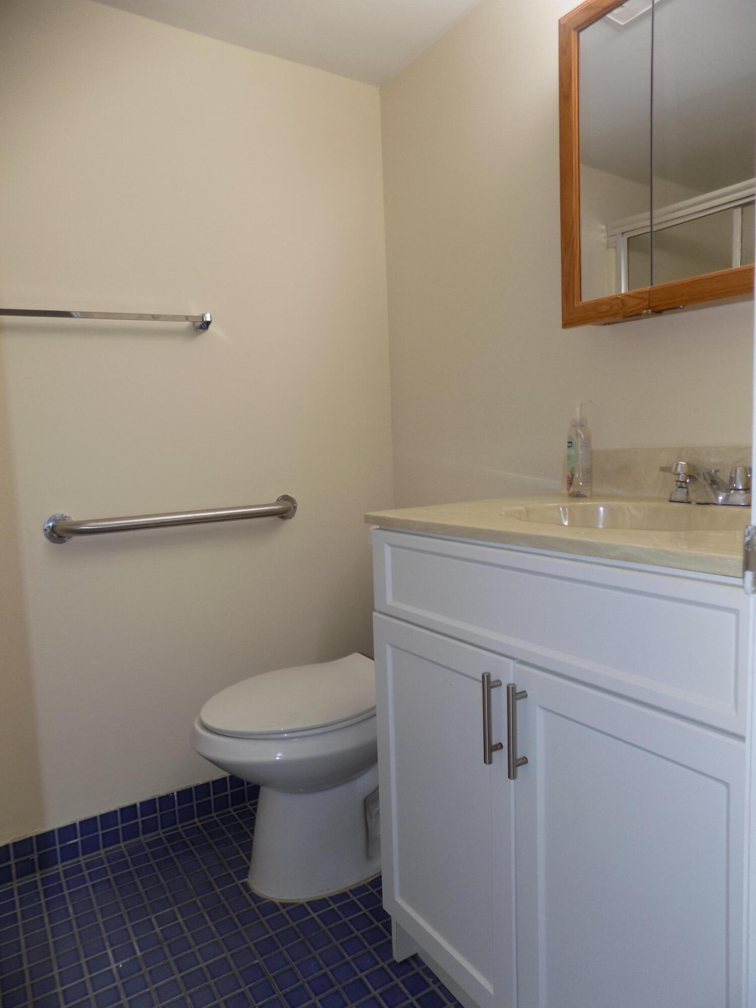 4181 South 57th Avenue, Unit B Greenacres, FL 33463 - Photo 16 of 25 a bathroom with a toilet sink and vanity