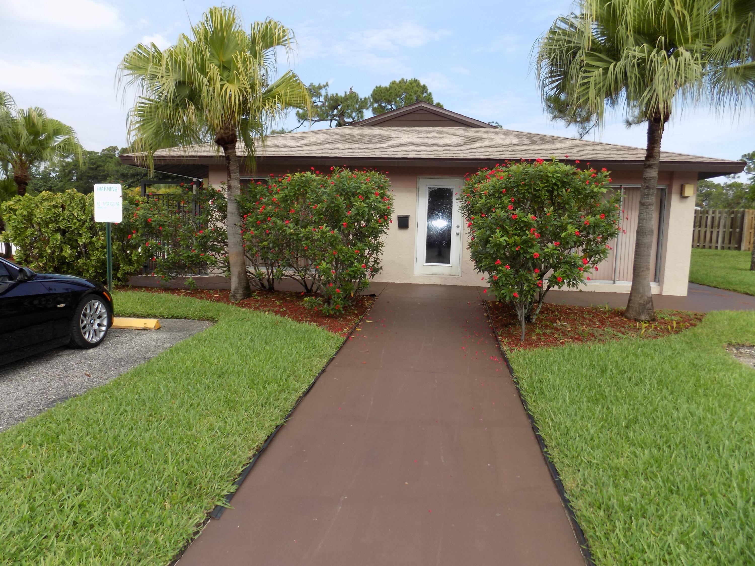4181 South 57th Avenue, Unit B Greenacres, FL 33463 - Photo 22 of 25 a front view of a house with a garden