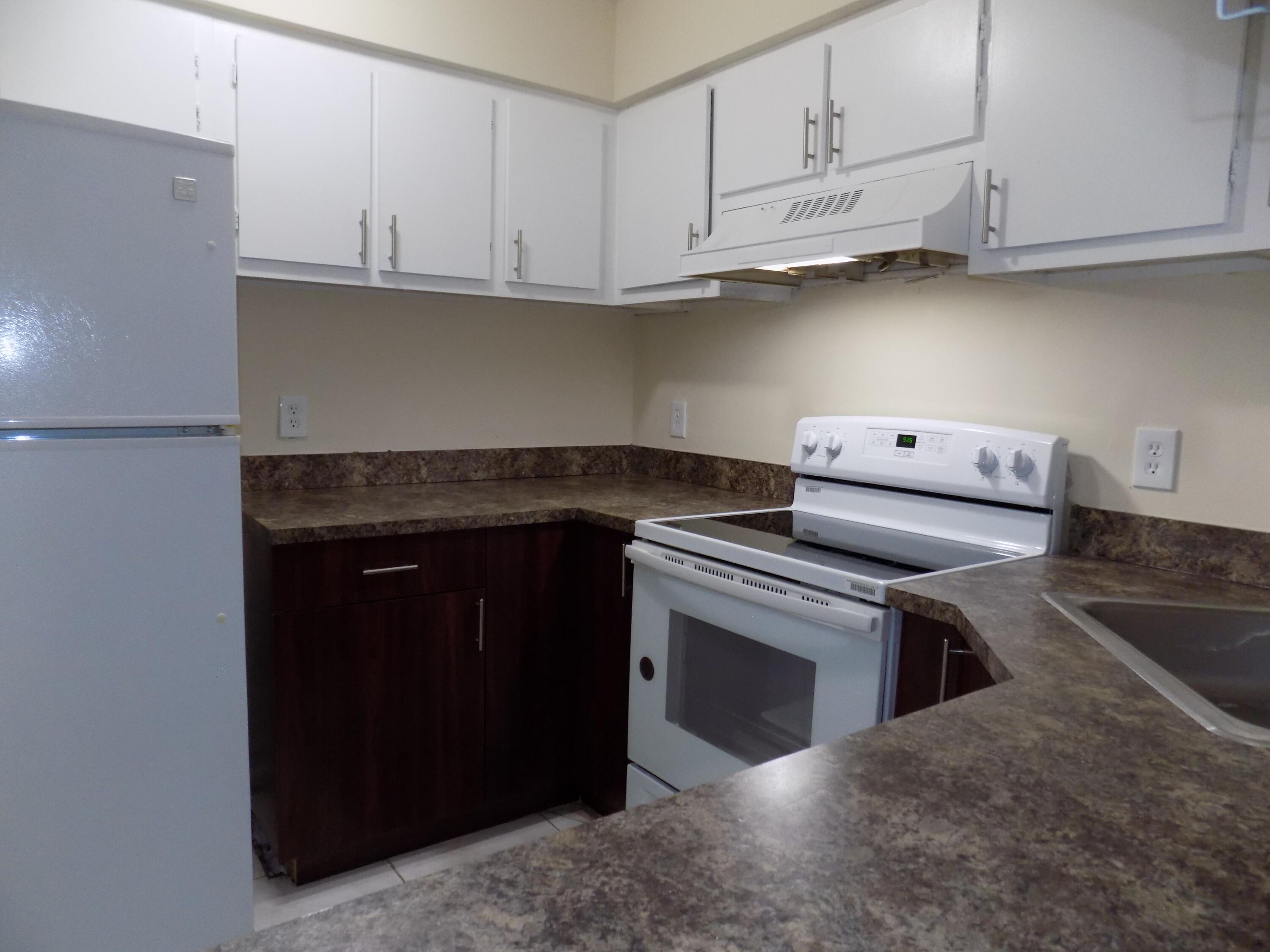 4181 South 57th Avenue, Unit B Greenacres, FL 33463 - Photo 3 of 25 a kitchen with stainless steel appliances granite countertop a stove and a refrigerator