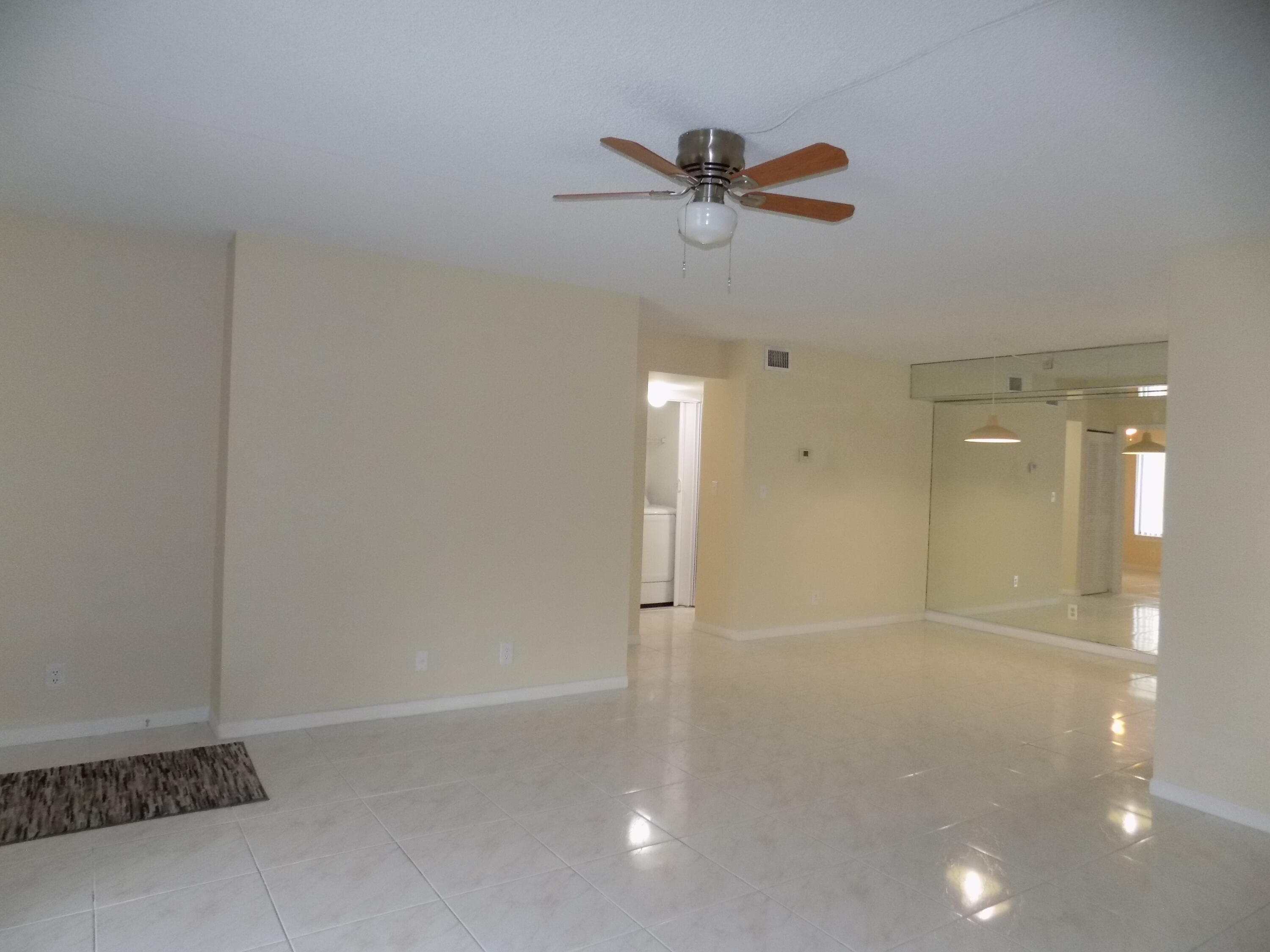 4181 South 57th Avenue, Unit B Greenacres, FL 33463 - Photo 9 of 25 a view of a livingroom with a chandelier fan and wooden floor