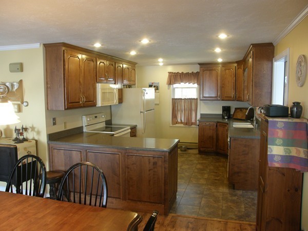 51 Colonial Road Webster, MA 01570 - Photo 9 of 30 a kitchen with stainless steel appliances granite countertop a sink a stove a dining table and chairs