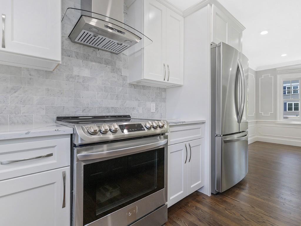 15 Marshfield Road Newton, MA 02459 - Photo 5 of 41 a kitchen with stainless steel appliances white cabinets and a wooden floor