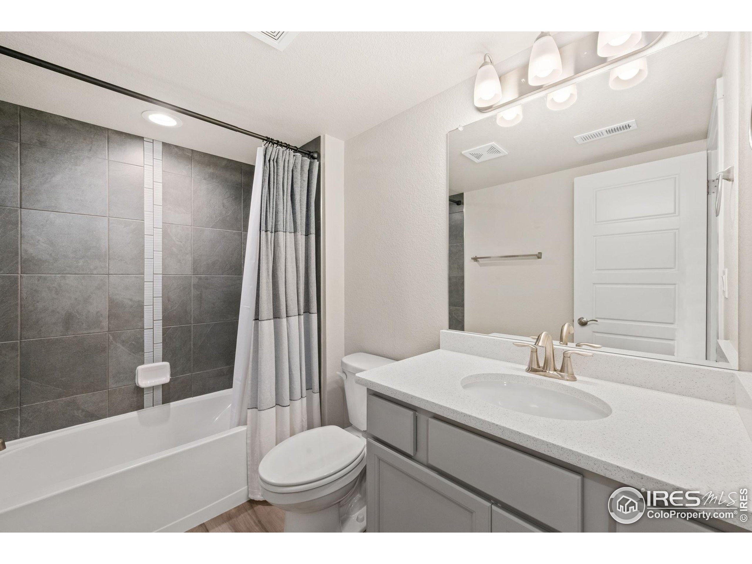 963 Milner Pass Road Severance, CO 80550 - Photo 32 of 42 a bathroom with a sink a toilet a mirror and bathtub