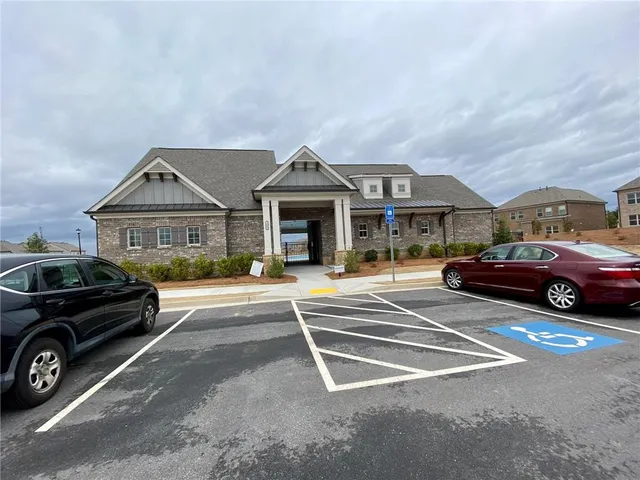 a front view of a house with lots of cars parked