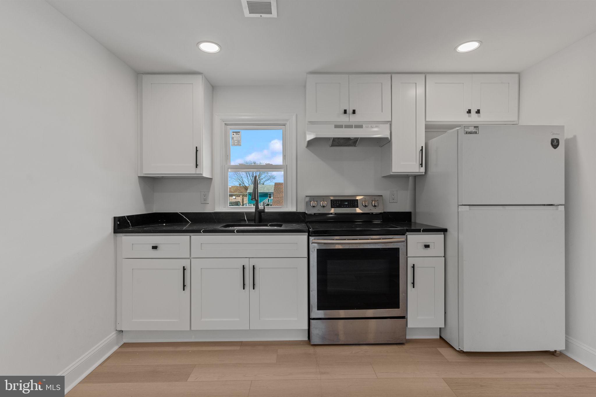 908 State Rd., Unit A Croydon, PA 19021 - Photo 5 of 9 a kitchen with granite countertop white cabinets and refrigerator