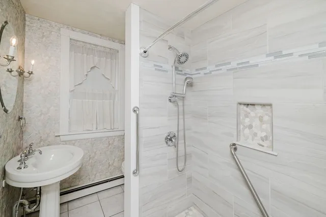 a bathroom with a sink shower and a mirror