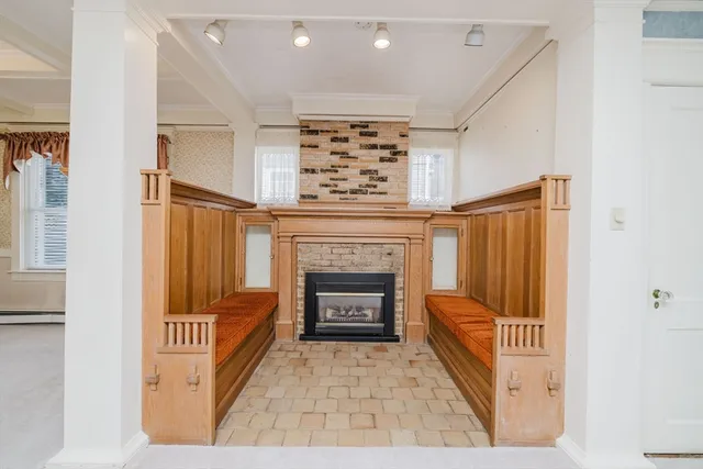 a view of a livingroom with a fireplace wooden floor and entryway